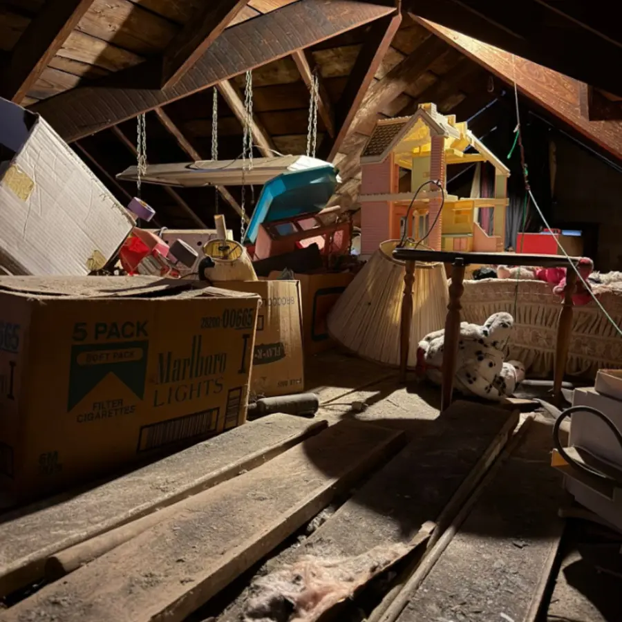 Attic with cardboard boxes and household items before cleanout