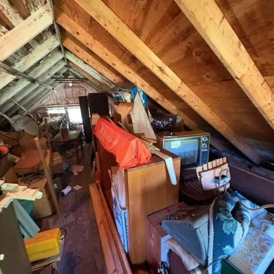 Attic filled with clothing and boxes before cleanout