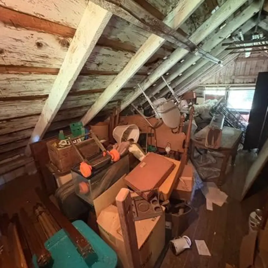 Attic with household furniture before cleanout