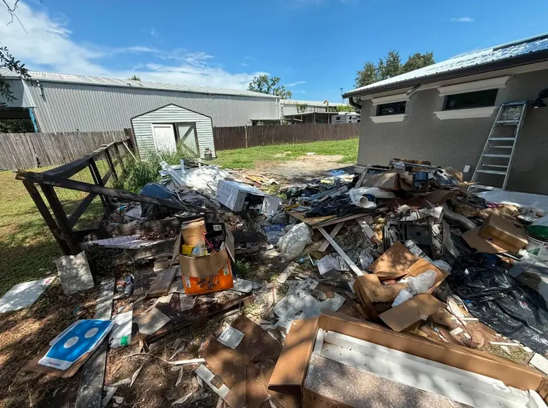 Outdoor renovation debris piled beside a home before JRT removal