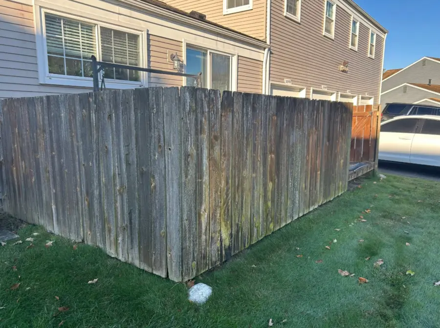 Weathered wood privacy fence before removal
