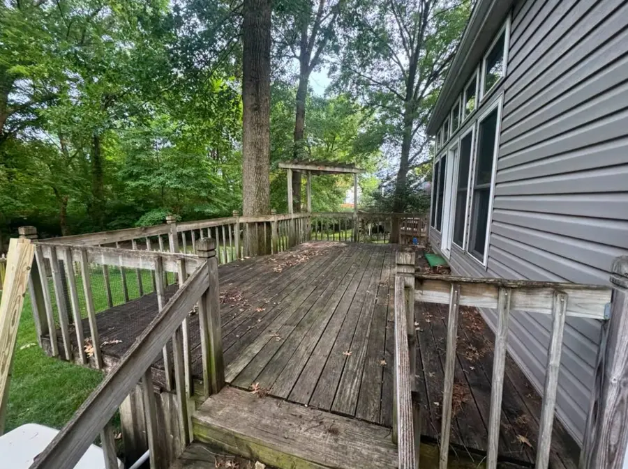 Large weathered deck around a mature tree before dismantling