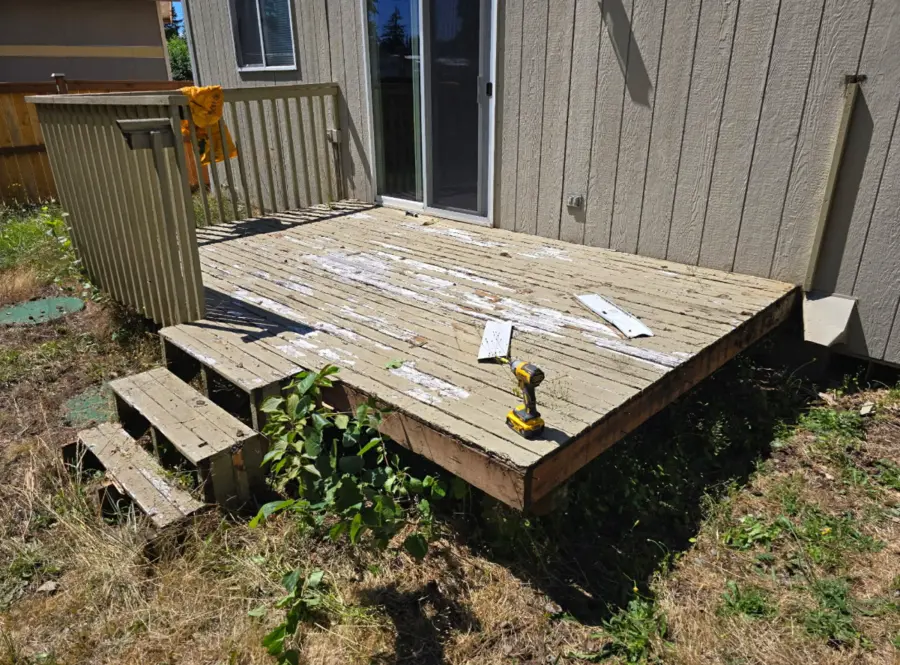 Small ground-level deck with steps before dismantling