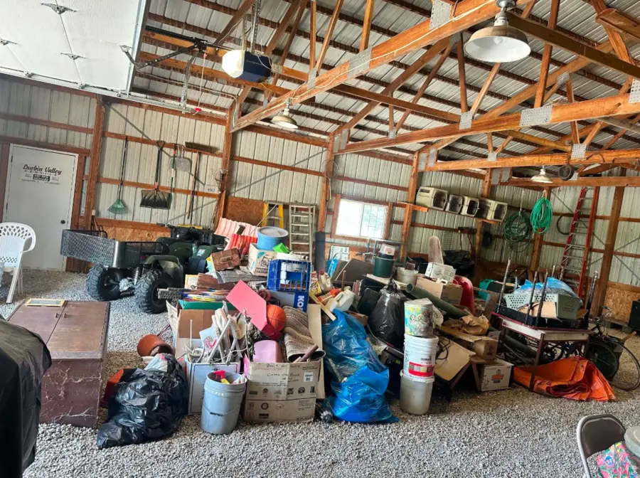 Large outbuilding filled with boxes, bags and household items before estate cleanout