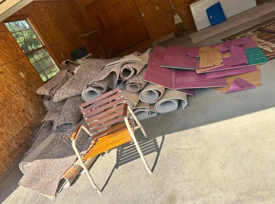Garage filled with rolled carpet and flooring before estate cleanout
