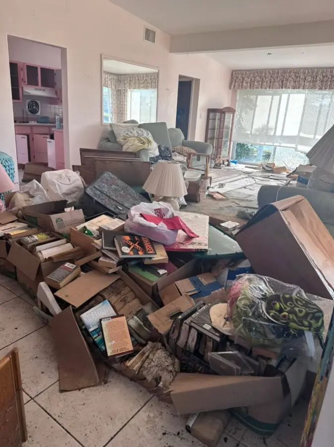 Living room filled with furniture, boxes and household belongings before estate cleanout