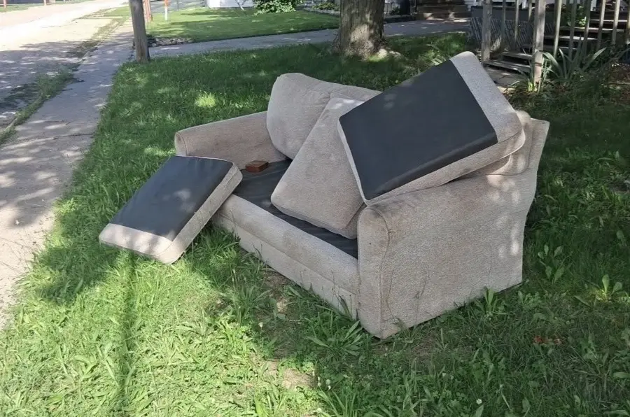 Sofa and cushions outside before curbside furniture pickup