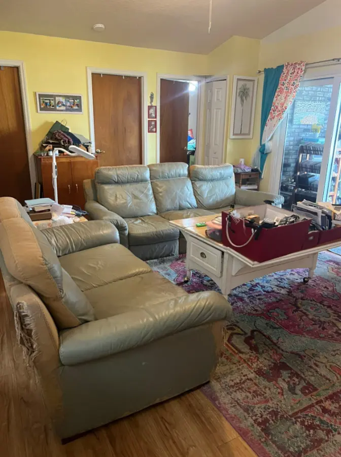 Living room with two large sectional sofas before removal
