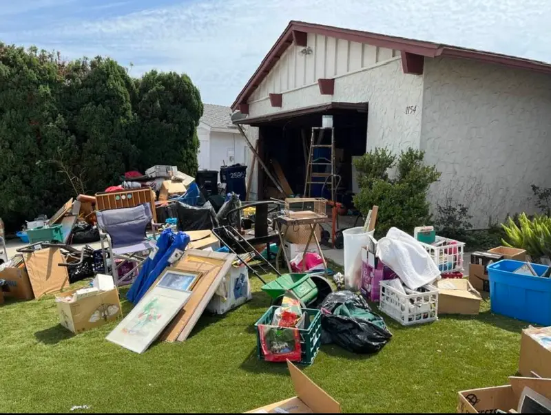 Large garage cleanout with furniture, boxes and household items ready for removal