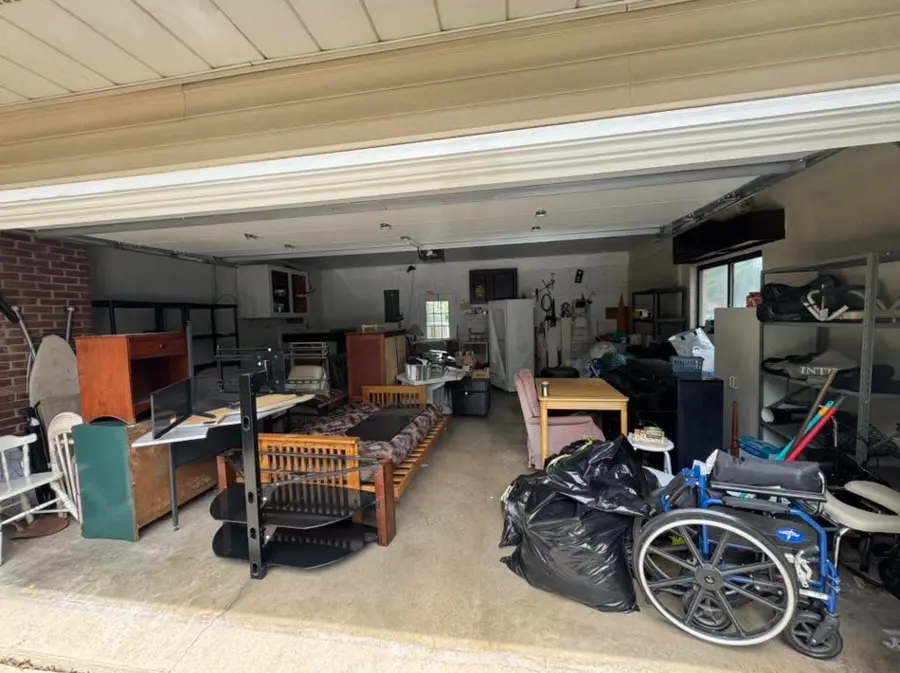 Large garage filled with furniture and mobility equipment before cleanout