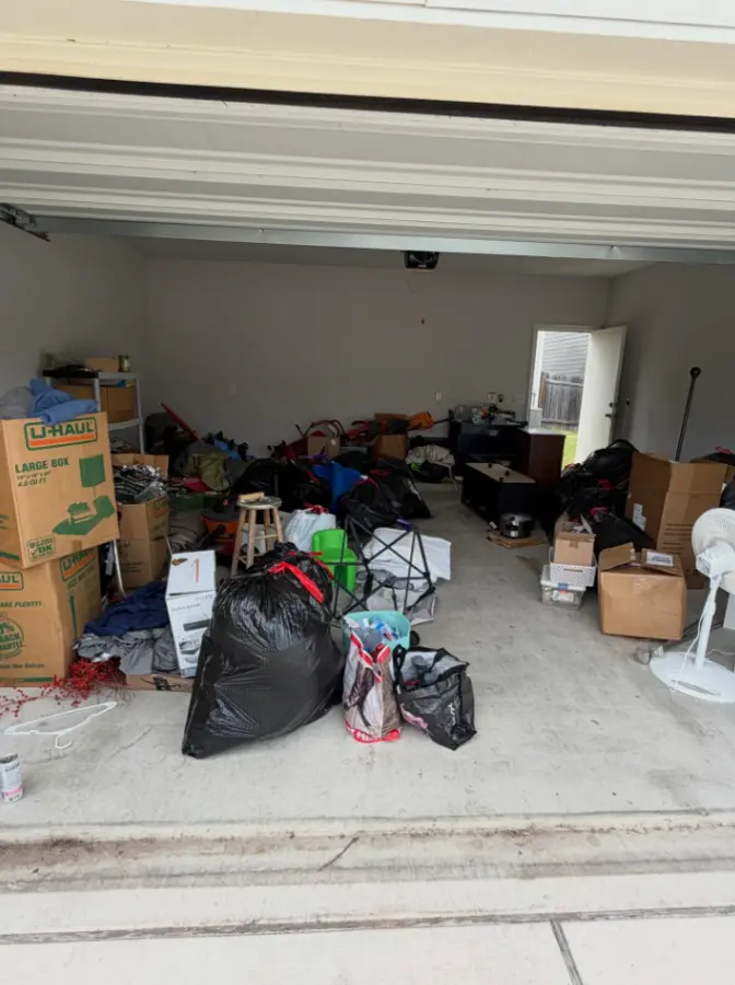 Garage with moving boxes, bags and household items before cleanout