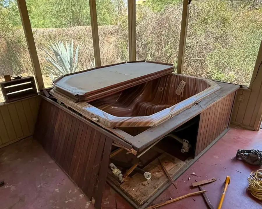 Hot tub being dismantled inside a screened porch