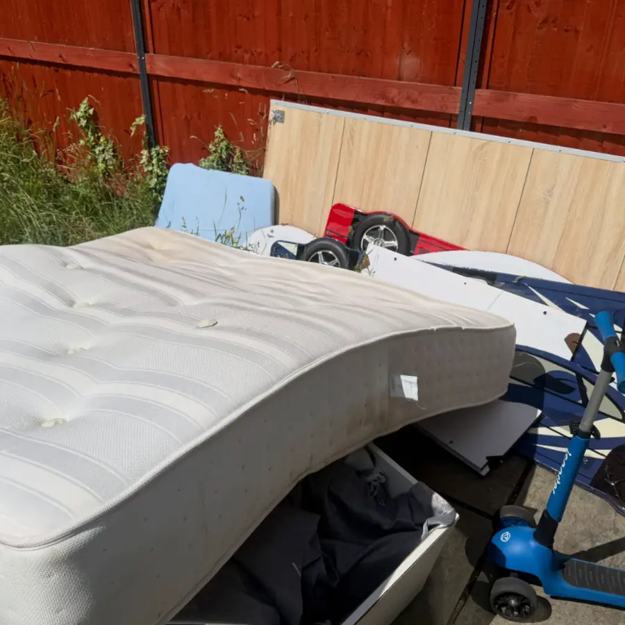 Mattress and household items outside before pickup