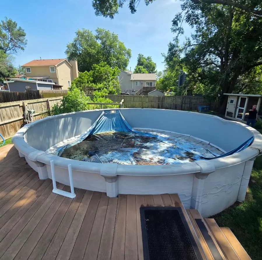 Above-ground pool beside a wood deck before removal