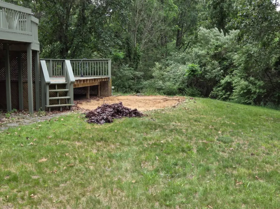 Yard cleared after pool removal beside raised deck