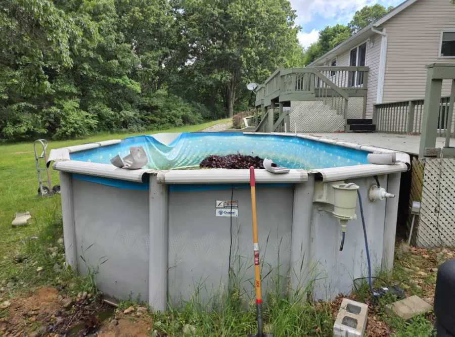 Above-ground pool next to a raised deck before removal