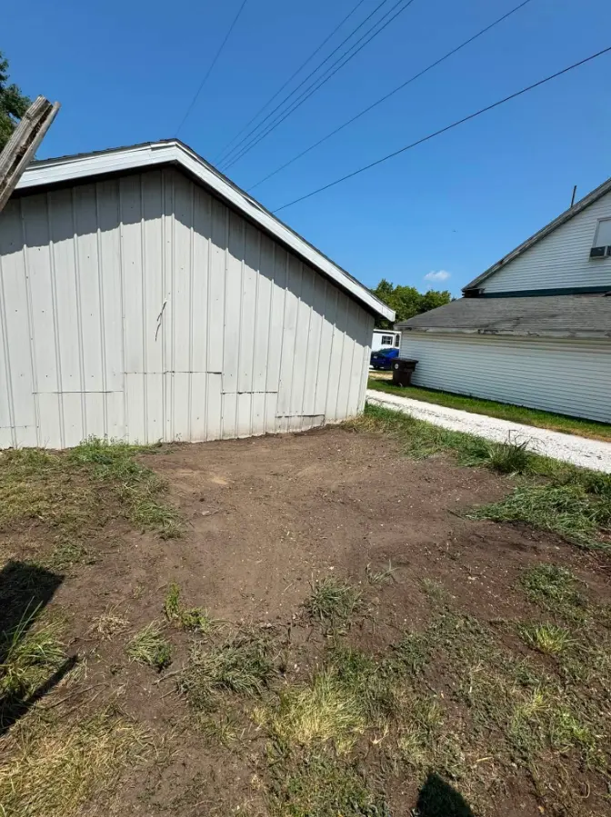 Open ground beside garage after utility shed removal