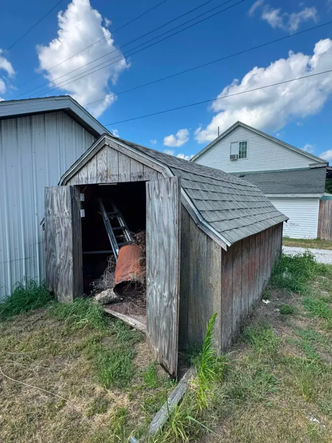 Small weathered utility shed before removal